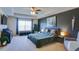 Spacious bedroom boasts a tray ceiling, large window, TV, and a cozy bed with decorative pillows and lamps at 156 Woodhouse Cir, Acworth, GA 30102