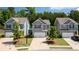 A picturesque street view showcasing three modern homes with well-manicured lawns and mature trees at 156 Woodhouse Cir, Acworth, GA 30102