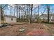Spacious backyard with outbuilding surrounded by trees, offering plenty of space for outdoor activities at 2325 Lago Dr, Jonesboro, GA 30236
