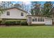 Two-story home featuring light siding, an attached garage, manicured lawn, and mature trees at 2325 Lago Dr, Jonesboro, GA 30236