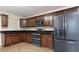 Kitchen features dark cabinets, granite countertops, stainless steel appliances, and tile floors at 2325 Lago Dr, Jonesboro, GA 30236