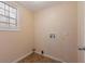Cozy laundry room featuring tile flooring and a utility sink at 2325 Lago Dr, Jonesboro, GA 30236
