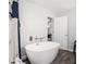 Bright bathroom featuring a standalone white tub with modern fixtures and dark tile flooring at 295 N Fayette Dr, Fayetteville, GA 30214