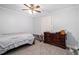 Neutral bedroom with a ceiling fan, dresser, and carpeted floors at 295 N Fayette Dr, Fayetteville, GA 30214