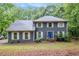 Charming two-story home with blue siding, white trim, bright blue front door, and mature trees at 295 N Fayette Dr, Fayetteville, GA 30214