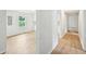 Bright hallway showcasing seamless hardwood floors and freshly painted walls leading to the kitchen at 6648 Florence Dr, Lithia Springs, GA 30122