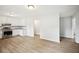 Open kitchen view showcasing stainless appliances, white cabinets, and light wood-look flooring at 6648 Florence Dr, Lithia Springs, GA 30122