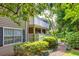 Exterior view of a property with a deck, lush landscaping, and a pathway, nestled in a wooded setting at 1750 Clairmont Rd # 32, Decatur, GA 30033