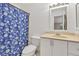 Clean and bright bathroom with white vanity, toilet, and blue floral shower curtain at 1750 Clairmont Rd # 32, Decatur, GA 30033