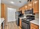 Galley kitchen with black appliances and view of pantry and wood cabinets with white countertops at 1750 Clairmont Rd # 32, Decatur, GA 30033