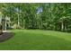 Expansive lawn and mature trees create a beautiful, private backyard setting at 305 Jasmine Ct, Woodstock, GA 30189