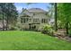 Well-manicured backyard with a two-story home, spacious deck with stairs, and verdant lawn at 305 Jasmine Ct, Woodstock, GA 30189