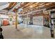 Unfinished basement with exposed ceiling, workbench, and garage doors at 305 Jasmine Ct, Woodstock, GA 30189