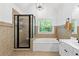 Bright bathroom featuring black framed shower, tub, tile surround, and natural light at 305 Jasmine Ct, Woodstock, GA 30189