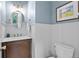 Charming powder room features custom vanity, mirror and modern lighting at 305 Jasmine Ct, Woodstock, GA 30189