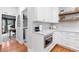 Charming kitchen area features white cabinets, marble countertops and stainless appliances at 305 Jasmine Ct, Woodstock, GA 30189