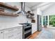 Gourmet kitchen features custom cabinets, stainless appliances and wooden shelves at 305 Jasmine Ct, Woodstock, GA 30189