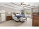 Bright main bedroom featuring tray ceiling, carpeted floors, bench, and many windows at 305 Jasmine Ct, Woodstock, GA 30189