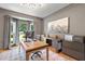 Well-lit home office with stylish light fixture, desk, artwork and gray colored walls at 305 Jasmine Ct, Woodstock, GA 30189