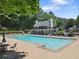 Resort-style community pool with lounge chairs and clubhouse, perfect for relaxing and entertaining at 305 Jasmine Ct, Woodstock, GA 30189