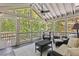 Well-lit screened porch with outdoor seating, ceiling fan and nature views at 305 Jasmine Ct, Woodstock, GA 30189