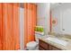 Bright bathroom showcasing decorative orange curtains, a granite countertop, and a white toilet at 6637 Chason Woods Ct, Jonesboro, GA 30238