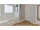 Clean bathroom with a large soaking tub and a separate shower area at 6637 Chason Woods Ct, Jonesboro, GA 30238