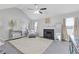 Large bonus room with fireplace, ceiling fan, and modern decor at 6637 Chason Woods Ct, Jonesboro, GA 30238