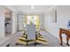 Formal dining room boasts modern chandelier, glass table, and stylish yellow accents at 6637 Chason Woods Ct, Jonesboro, GA 30238