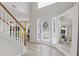 Inviting foyer featuring wood floors, a staircase, a large decorative mirror, and a view of the front door at 6637 Chason Woods Ct, Jonesboro, GA 30238