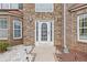 Close-up of the stone-accented front entrance featuring a decorative white door with sidelights and manicured landscaping at 6637 Chason Woods Ct, Jonesboro, GA 30238