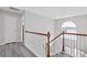 Upstairs hallway with wood railing, laminate flooring, and natural light from the windows at 6637 Chason Woods Ct, Jonesboro, GA 30238