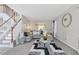 Cozy living room featuring a plush sectional sofa, a decorative rug, and a staircase in the background at 6637 Chason Woods Ct, Jonesboro, GA 30238