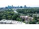 Aerial view of building surrounded by lush greenery and a distant city skyline at 130 26Th St # 402, Atlanta, GA 30309