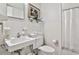 Classic white bathroom with vintage fixtures, a pedestal sink, and tiled shower, offering a clean and timeless appeal at 130 26Th St # 402, Atlanta, GA 30309