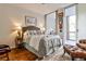 Cozy bedroom featuring a queen bed, warm wood floors, and access to a sunroom, ideal for relaxing after a long day at 130 26Th St # 402, Atlanta, GA 30309