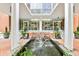 Building entrance with fountain, flowers, and a modern architectural design at 130 26Th St # 402, Atlanta, GA 30309