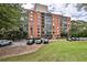 Brick building exterior featuring a covered entrance, parking, and a well-maintained lawn at 130 26Th St # 402, Atlanta, GA 30309