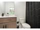 A bright bathroom with wood cabinets, white countertops, and a shower with stylish zig-zag curtain at 2505 Astaire Nw Ct, Atlanta, GA 30318