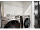 Modern laundry room with front load washer and dryer, sleek dark door and a wire shelf at 2505 Astaire Nw Ct, Atlanta, GA 30318