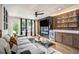 Spacious living room with a large couch, wet bar, and backyard view at 2505 Astaire Nw Ct, Atlanta, GA 30318