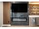 Living room with fireplace, TV, wooden feature wall, and modern wet bar at 2505 Astaire Nw Ct, Atlanta, GA 30318