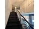 Modern staircase featuring sleek black railings and a view of the home's light-filled, open floor plan at 3000 Keeneland Blvd, Mcdonough, GA 30252