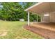 Covered wooden deck overlooking a spacious yard with mature trees, featuring an outbuilding for storage at 3781 Cherokee Trl, Suwanee, GA 30024