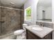 Bathroom featuring a vanity with a granite counter, toilet, and stand-up shower with stone-style tile at 3781 Cherokee Trl, Suwanee, GA 30024