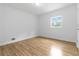 Bedroom featuring wood-look flooring, neutral walls, and a window providing natural light at 3781 Cherokee Trl, Suwanee, GA 30024