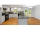 Newly remodeled kitchen showcases sleek white cabinetry, granite countertops, stainless steel appliances and hardwood floors at 3781 Cherokee Trl, Suwanee, GA 30024