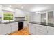 Modern kitchen with white cabinets, granite countertops, stainless steel appliances and natural light from the backyard at 3781 Cherokee Trl, Suwanee, GA 30024