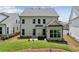 Backyard featuring a well-maintained lawn, patio area, and the rear elevation of the home with ample windows at 1589 Bennett Creek Overlook, Suwanee, GA 30024