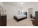 Cozy bedroom with a large bed, neutral carpet, and a doorway to a walk-in closet or en-suite office space at 1589 Bennett Creek Overlook, Suwanee, GA 30024